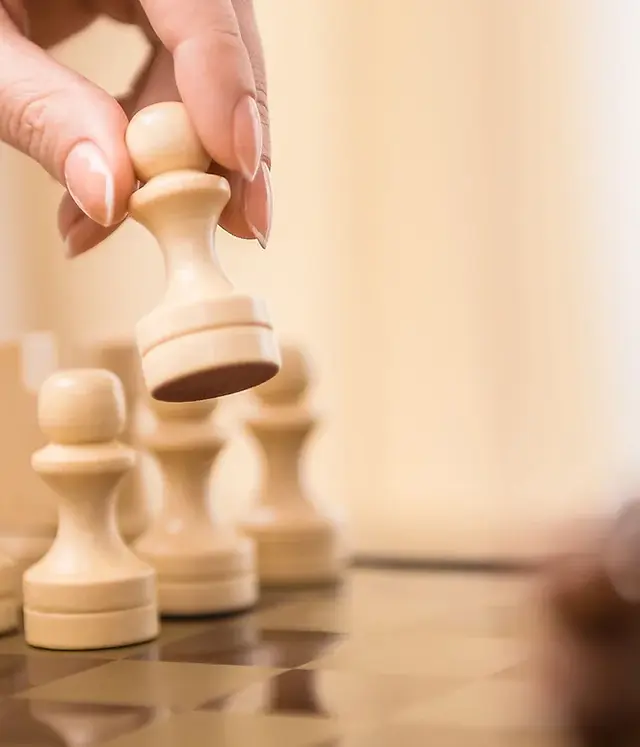 Hand picking a chess piece representing strategic planning